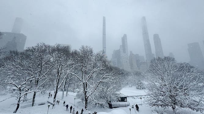 Pedestrians walk through snow in Central Park during a winter storm in New York, US, on Monday, Feb. 23, 2026.