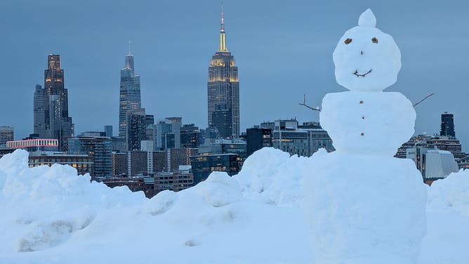 HOBOKEN, NJ - FEBRUARY 23: A snowman stands in a park in front of the skyline of midtown Manhattan and the Empire State Building in New York City following a snowstorm on February 23, 2026, in Hoboken, New Jersey.