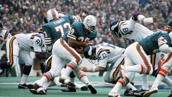 HOUSTON, TX - JANUARY 13: Larry Csonka #39 of the Miami Dolphins carries the ball and gets hit by Roy Winston #60 of the Minnesota Vikings during Super Bowl VIII at Rice Stadium January 13, 1974 in Houston, Texas. The Dolphins won the Super Bowl 24-7.