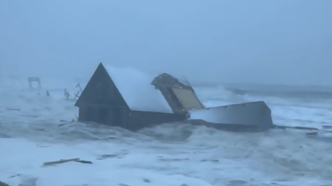 A collapsed beach house breaks apart in the ocean after collapsing on the beach of Buxton, North Carolina, on Feb. 1, 2026.
