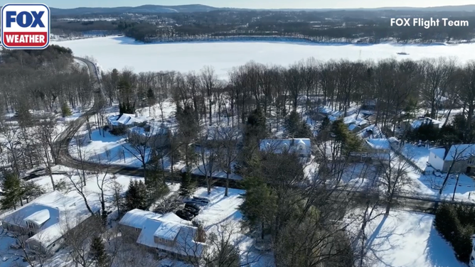 A wide shot shows snow-covered roofs in River Vale, NJ.
