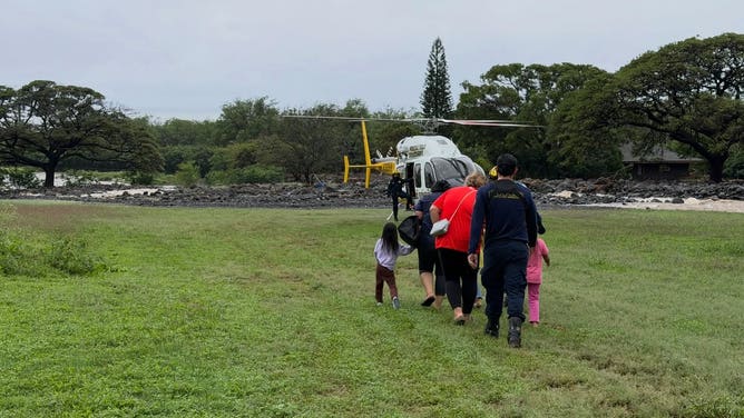 Campers rescued from Lady of Keaʻau on O'ahu walk to a heiicopter.
