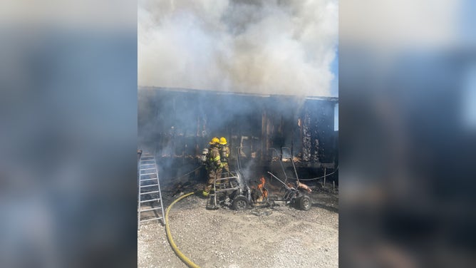 Members of the Carencro Fire Department extinguish a house fire while rescuing a dog trapped inside.