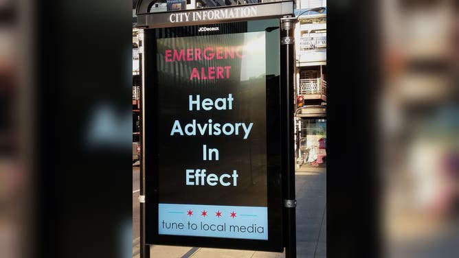 Close-up of a City Information Panel which displays 'Emergency Alert, Heat Advisory In Effect,' Chicago, Illinois, August 27, 2018.