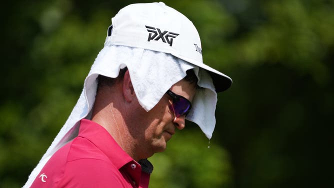 GREENSBORO, NORTH CAROLINA - AUGUST 05: Zach Johnson of the United States cools off on the 13th teeduring the second round of the Wyndham Championship at Sedgefield Country Club on August 05, 2022 in Greensboro, North Carolina.