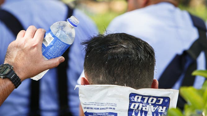 Houston Firefighters try to stay cool while battling a fire at South Houston home on Cortelyou Ln. near Nassau Rd. that spread to an adjoining house Monday, Aug. 9, 2010, in Houston.