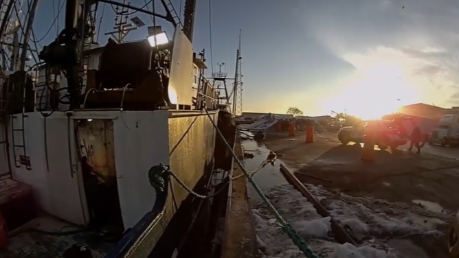 Massachusetts police officers arrive at the scene of a rescue of a fisherman who fell in the water between two boats.
