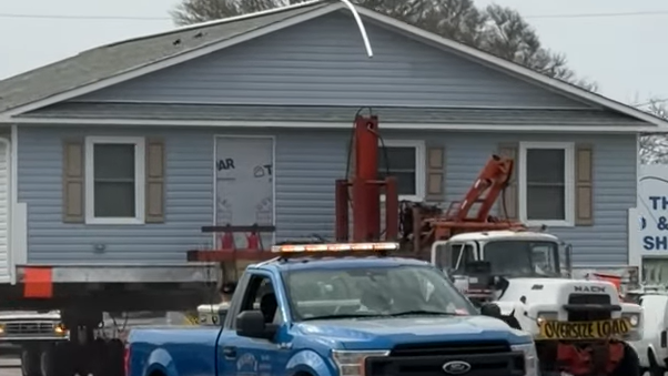 An entire house being transported off an exposed North Carolina beach last week created an unusual traffic jam that was caught on video. The home was a wide load on a flatbed truck, and was just narrow enough to cross over the narrow Holden Beach Bridge that connects the barrier island to the mainland.