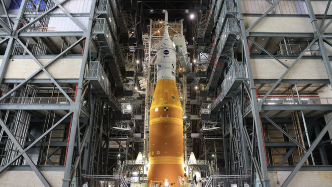 NASA’s Artemis II SLS (Space Launch System) rocket and Orion spacecraft, secured to the mobile launcher, stands vertical inside the Vehicle Assembly building on Tuesday, March 17, 2026, as preparations continue for rollout to Launch Complex 39B at NASA’s Kennedy Space Center in Florida.