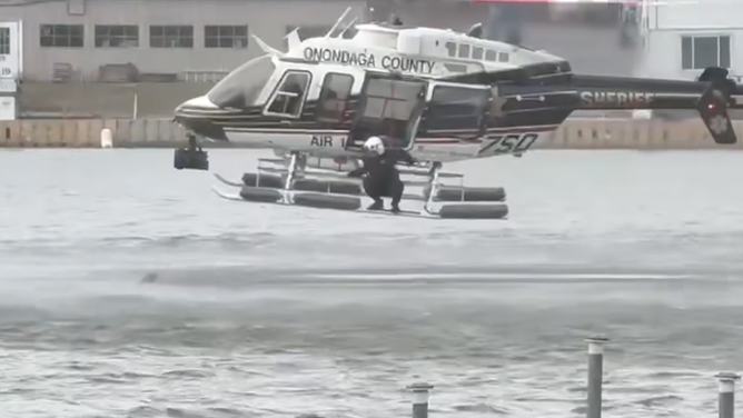 An Air1 crew member from the Onondaga County Sheriff’s Office walked along the helicopter’s skid to the rear, secured himself to the aircraft, and guided the pilot toward the dog.
