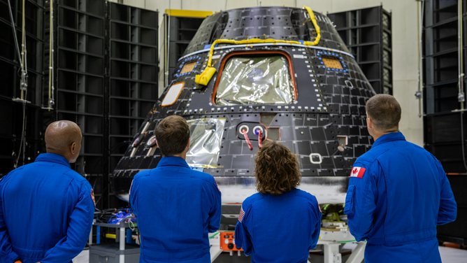 Artemis II crew members, shown inside the Neil Armstrong Operations and Checkout Building at NASA’s Kennedy Space Center in Florida, check out their Orion crew module on Aug. 8, 2023. 