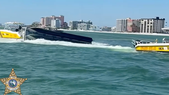 Crews tow boat after it capsized carrying 11 people near Fort Myers Beach Tuesday, March 24.