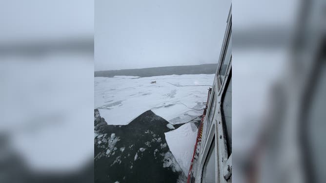 Members of the U.S. Coast Guard locate a stranded snowmobile operator floating on ice in Michigan.