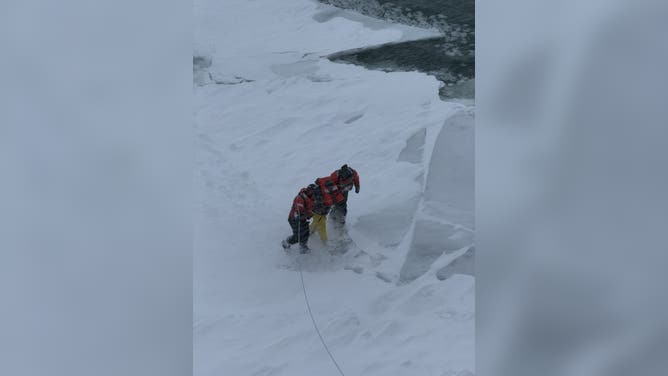 Members of the U.S. Coast Guard rescue a stranded snowmobile operator in Michigan.