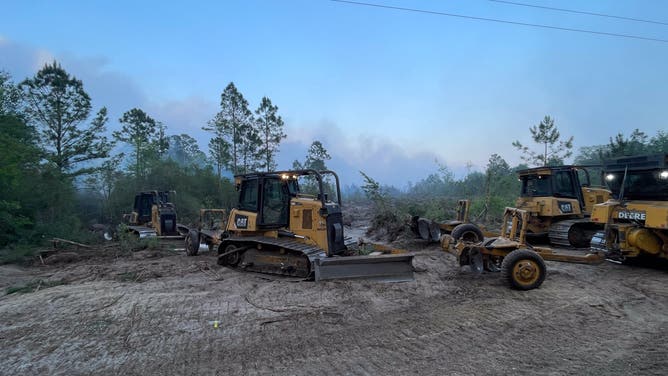 Crews work to removed downed trees among the Highway 82 Fire zone on April 25, 2026.