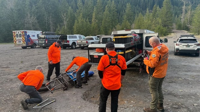 First responders prepare a wheeled litter to extract an injured hiker in Oregon.