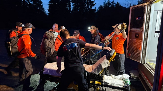 First responders load an injured hiker into an ambulance for transport to a hospital.