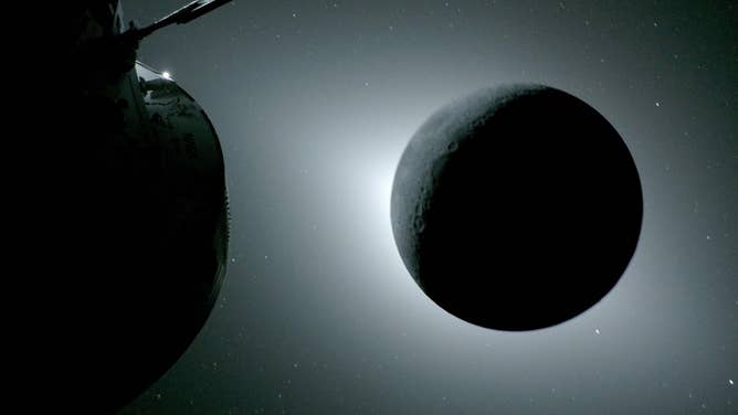 (April 6, 2026) - The Moon, seen here backlit by the Sun during a solar eclipse on April 6, 2026, is photographed by one of the cameras on the Orion spacecraft’s solar array wings. Orion is visible in the foreground on the left. Earth is reflecting sunlight at the left edge of the Moon, which is slightly brighter than the rest of the disk. The bright spot visible just below the Moon’s bottom right edge is Saturn. Beyond that, the bright spot at the right edge of the image is Mars. 