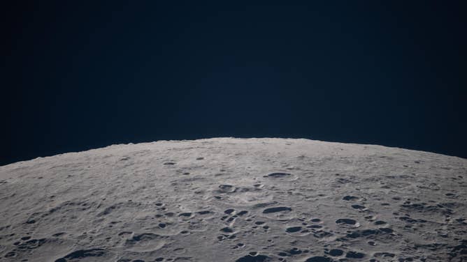 (April 6, 2026) – As the Artemis II crew passes the Moon during an observation period, the lunar landscape sharpens into focus: a terrain scattered with craters and shadows stretching beneath the black expanse of space.