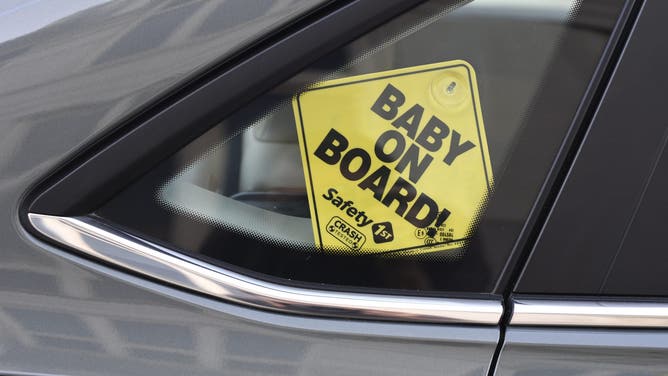 NASHVILLE, TENNESSEE - SEPTEMBER 2, 2019: A 'Baby On Board!' sign hangs in the back window of a car in Nashville, Tennessee.