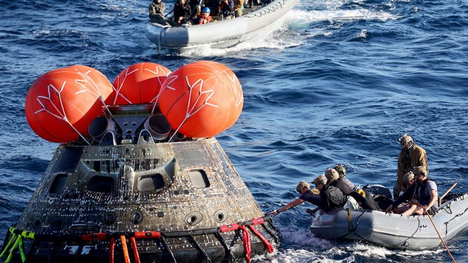 US Navy divers secure NASA's Orion Capsule during recovery operations following a successful uncrewed Artemis I moon mission after it splashed down in the Pacific Ocean off the coast of Baja California, Mexico, on December 11, 2022. Orion was launched November 16 on the Artemis rocket for a 25-day mission to the Moon. The main goal of this mission was to test Orion's heat shield -- for the day when it is humans and not test mannequins riding inside.