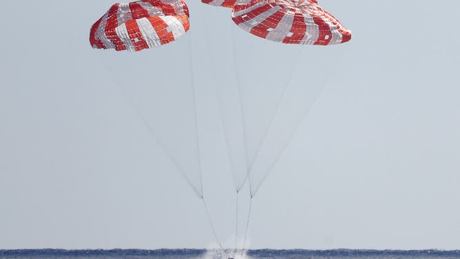 AT SEA, PACIFIC OCEAN - DECEMBER 11: NASA's Orion Capsule splashes down after a successful uncrewed Artemis I Moon Mission on December 11, 2022 seen from aboard the U.S.S. Portland in the Pacific Ocean off the coast of Baja California, Mexico. A 26-day mission took the Orion spacecraft to the moon and back which completed a historic test flight that coincided with the 50th anniversary of the landing of Apollo 17 on the moon, the last time that NASA astronauts walked there.