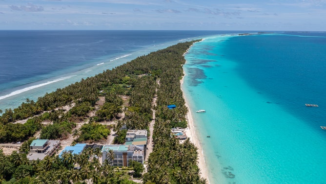 Narrow Island in indian Ocean on Maldives surounded by blue water aerial view, Dhigurah