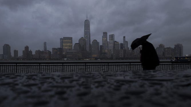 JERSEY CITY, NJ - OCTOBER 12: Raindrops form on the top of a monument in front of the skyline of lower Manhattan and One World Trade Center as a nor'easter storm moves into New York City on October 12, 2025, as seen from Jersey City, New Jersey.