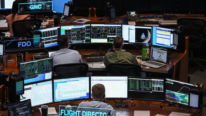 Artemis II controllers monitor the progress of the Orion spacecraft in the White Flight Control Room at Johnson Space Center in Houston, Texas, on April 3, 2026. Four Artemis astronauts were zooming towards the Moon late April 2 after a major engine firing, a milestone that commits NASA to the first crewed lunar flyby in more than half a century. With enough thrust to accelerate a stationary car to highway driving speed in less than three seconds, the Orion capsule engine blasted the astronauts on their trajectory towards the Moon, which they now will loop as part of the 10-day Artemis II mission. 