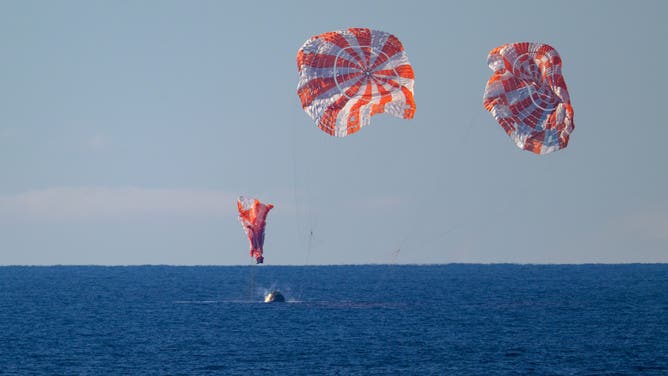 NASA's Orion spacecraft with Artemis II crewmembers NASA astronauts Reid Wiseman, commander; Victor Glover, pilot; Christina Koch, mission specialist; and CSA (Canadian Space Agency) astronaut Jeremy Hansen, mission specialist aboard are seen as it lands in the Pacific Ocean off the coast of California, Friday, April 10, 2026. 