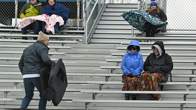 FILE- LATHAM, NY - APRIL 7: Fans are bundled up as they watch a lacrosse game between Shenendehowa and Shaker from the cold bleachers on Tuesday, April 7, 2026 in Latham, N.Y. 