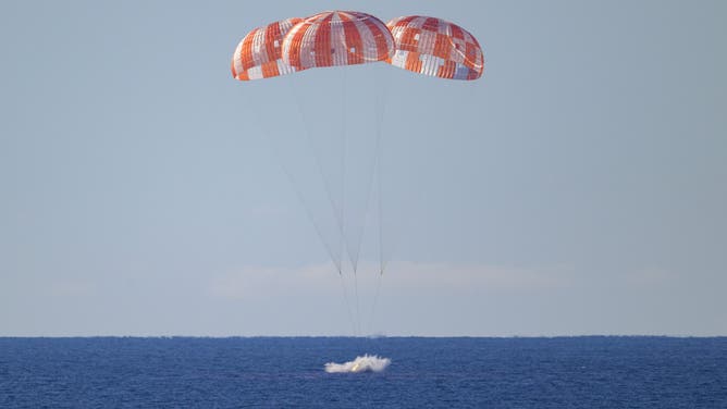NASA’s Orion spacecraft with Artemis II crewmembers NASA astronauts Reid Wiseman, commander; Victor Glover, pilot; Christina Koch, mission specialist; and CSA (Canadian Space Agency) astronaut Jeremy Hansen, mission specialist aboard is seen as it lands in the Pacific Ocean off the coast of California, Friday, April 10, 2026. NASA’s Artemis II mission took Wiseman, Glover, Koch, and Hansen on a 10-day journey around the Moon and back to Earth. Following a splashdown at , NASA, U.S. Navy, and U.S. Air Force teams are working to bring the crewmembers and Orion spacecraft aboard USS John P. Murtha. Photo Credit: (NASA/Bill Ingalls)