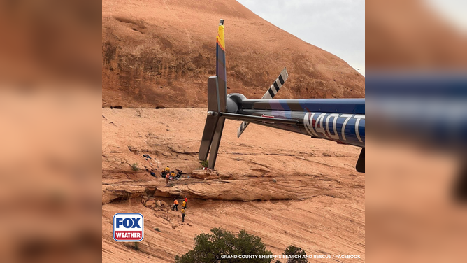 Helicopter team stands by while first responders secure and prepare an injured hiker for transport in Utah.