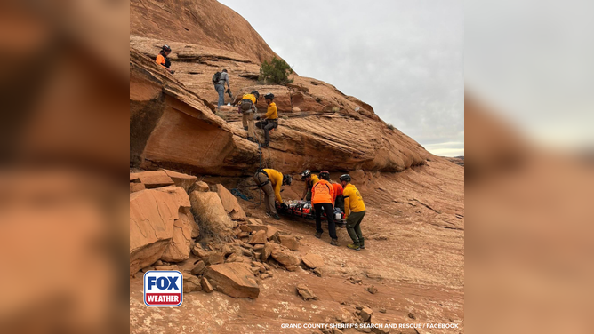 Members of the Grand County Sheriff’s Search and Rescue team lower the injured hiker using a rope system from a gully.