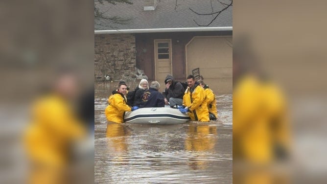 Firefighters rescued three people from a home amid rising floodwaters in Suamico, Wisconsin, Tuesday, April 14