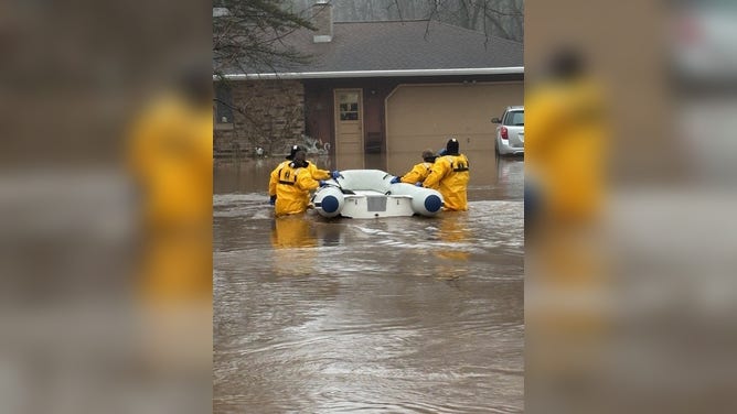 Firefighters rescued three people from a home amid rising floodwaters in Suamico, Wisconsin, Tuesday, April 14
