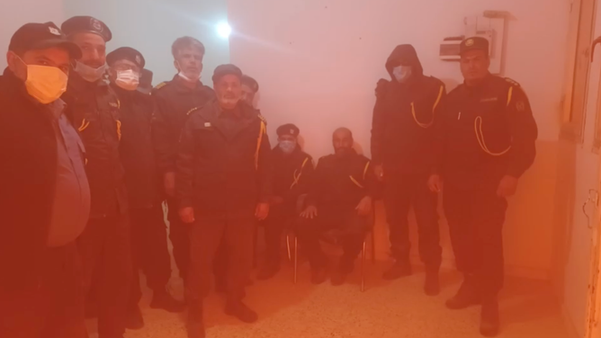 People stand in masks as the dust storm causes the sky to turn bright red.