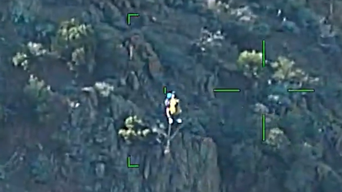 An injured California is hoisted to safety by a helicopter.