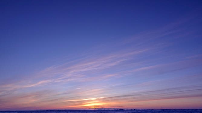 UTQIAVIK, AK - APRIL 9: The sun sets beyond the frozen, snow covered Arctic Ocean in Utqiavik, AK on April 9, 2019.