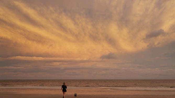 BILOXI, MISSISSIPPI - SEPTEMBER 14: Taylor Lavender and her dog, Bailey, enjoy the beach on September 14, 2020 in Biloxi, Mississippi.