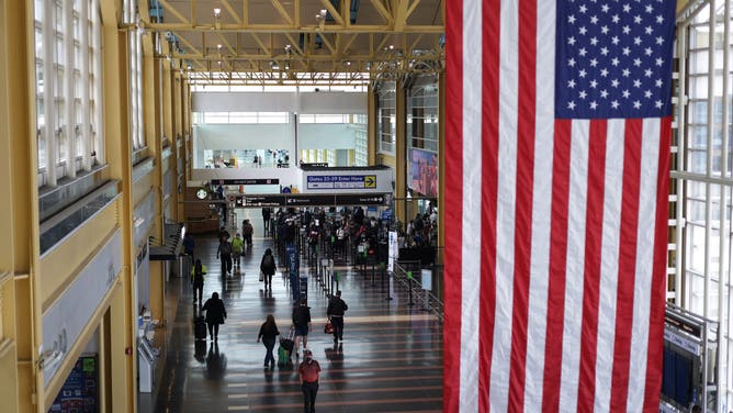 WASHINGTON, DC - MAY 25: Travelers walk through the concourse with their luggage at Ronald Reagan Washington National Airport May 25, 2021 in Arlington, Virginia.