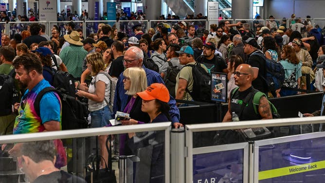Travelers queue at Miami International Airport during Memorial Day weekend on May 24, 2025 in Miami, Florida.