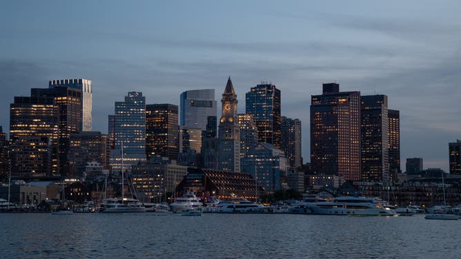 The Boston skyline at night is visible from Boston Harbor in Boston, USA, on July 2, 2024.