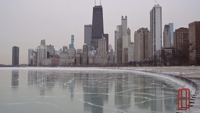 CHICAGO, ILLINOIS - JANUARY 24:A wide-angle view shows the downtown Chicago skyline reflected in the partially frozen surface of Lake Michigan on January 24, 2026.