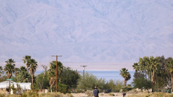 SALTON CITY, CALIFORNIA - APRIL 30: A person walks with the Salton Sea in the distance on April 30, 2026 in Salton City, California. California has launched the Salton Sea Conservancy, its first new conservancy in more than 15 years, in an effort to support long-term habitat restoration while improving air quality around the deteriorating inland lake. The Salton Sea, located in the desert in Southern California, has been shrinking for decades and is now nearly twice as salty as the ocean while contaminated by pollutants including agricultural runoff. A deposit of geothermal brine beneath the Salton Sea is believed to hold one of the planet’s largest reserves of lithium and is worth an estimated $500 billion. The lithium could bring jobs to the region and help power electric vehicles, smartphones, and electricity grids while some residents are concerned that lithium extraction could exacerbate environmental issues. In 2022, Governor Gavin Newsom has called the area 