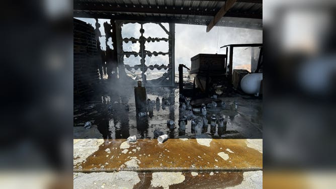 Honey and other equipment lay on the ground after a fire.