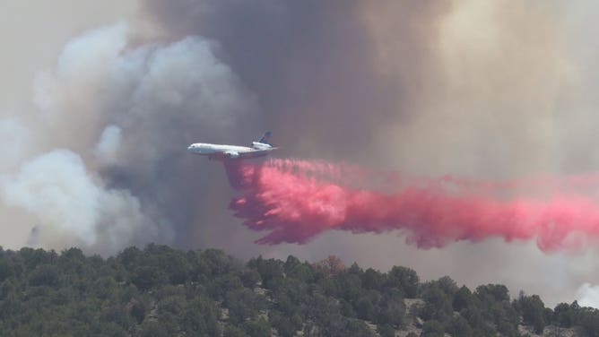 A plane drops fire retardant onto the Cottonwood Fire on June 23.