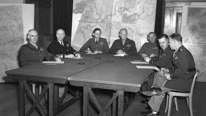 66-309-1 Allied invasion chiefs at a press conference in Allied Command Headquarters, London, England, are, left to right: Lt. Gen. Omar Bradley, Commanding U.S. Army Ground Forces; Admiral Sir B. Ramsay, Allied Naval Operations; Air Chief Marshal Sir Arthur Tedder, Deputy Supreme Commander; General Dwight D. Eisenhower, Spreme commander; General Sir B. Montgomery, Commander in Chief, British Armies; Air Chief Marshal Sir T. Leigh-Mallory; and Lt. Gen. W. Bedell-Smith, Chief of Staff. London, England, 12 February 1944.