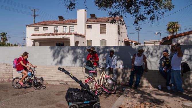 CALEXICO, CA - AUGUST 31: A group of men sit underneath a tree for shade amid a heatwave on August 31, 2022 in Calexico, California. 