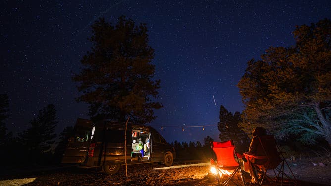 WILLIAMS, ARIZONA - JANUARY 08: An extended exposure of a vanlifer outside of a converted Sprinter camper van in the Kaibab National Forest on January 08, 2021 in Williams, Arizona.